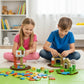 Zwei Kinder sitzen nebeneinander auf dem Boden und bauen gemeinsam Häuser aus den bunten Klugolino Magnetwürfeln.